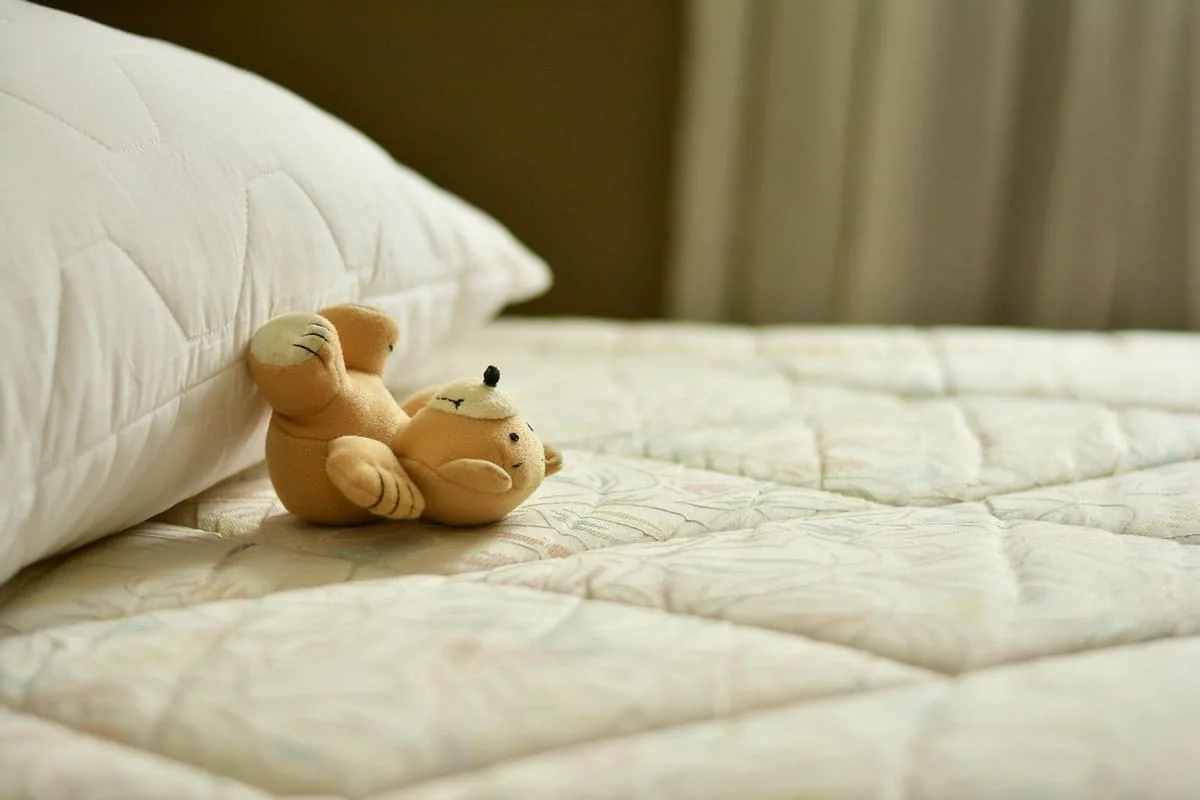 No puedo dormir: qué hago para que me dé sueño, cama con almohada y peluche que representa el insomnio y la dificultad para conciliar el sueño