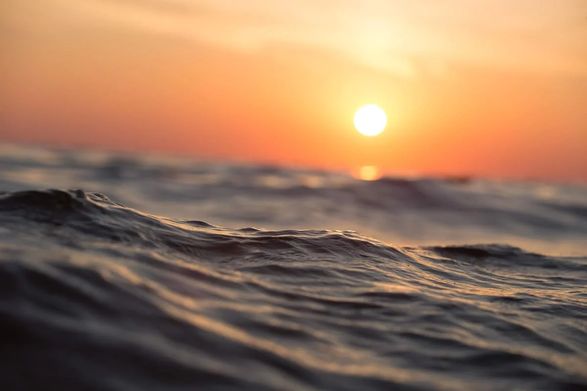 Como disfrutar del verano desde la psicología contemplando un atardecer sobre el mar como símbolo de descanso y bienestar emocional