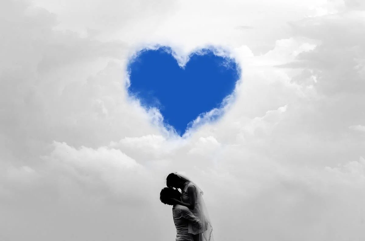 Cuánto dura el enamoramiento según la psicología: pareja enamorada bajo un corazón azul